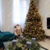 Künstlicher Weihnachtsbaum grün groß und breit, verziert mit Gold- und Kupferornamenten im Wohnzimmer