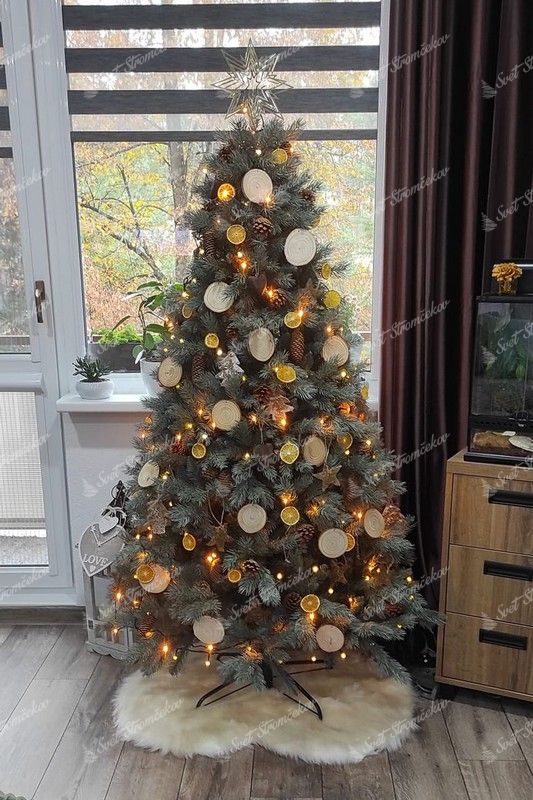 strieborný umelý vianočný stromček, ozdobený šiškami a prírodnými ozdobami