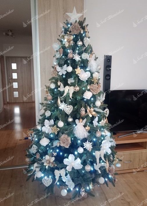 Zelený umelý vianočný stromček, ozdobený bielo-zlatými ozdobami.