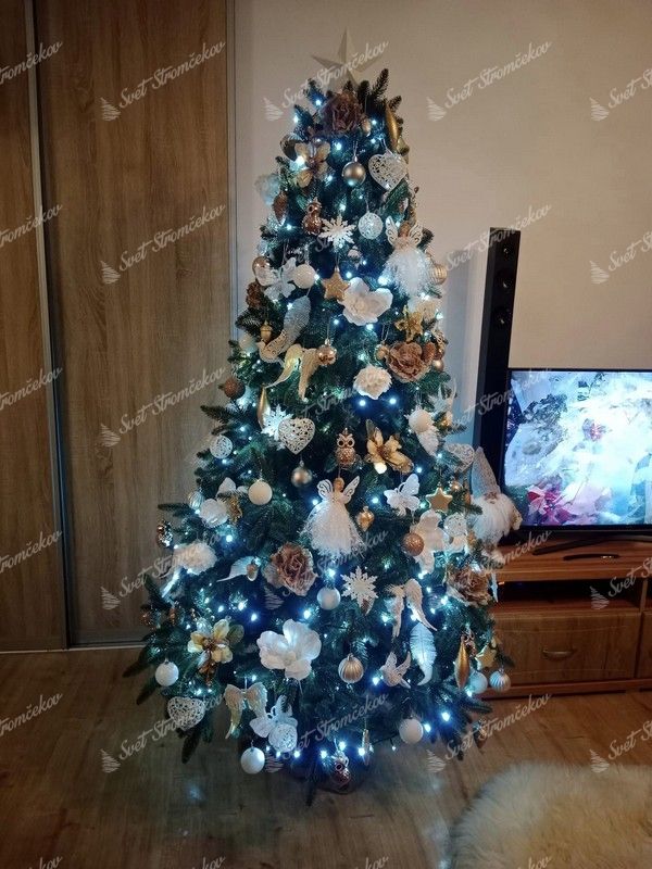 Zelený umelý vianočný stromček, ozdobený zlato-bielymi ozdobami