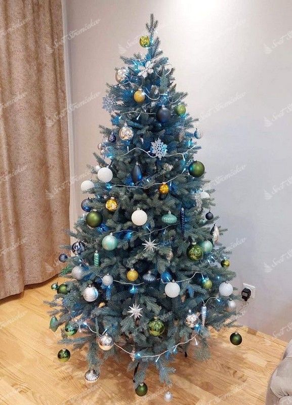 Umelý vianočný stromček so zeleno-striebornými vetvičkami, s bielo-strieborno-zelenou vianočnou výzdobou.