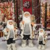 Weihnachtsdekoration Nikolaus in Grau, mit einem grauen Mantel mit Fellbesatz und einem Kuscheltier in der Hand