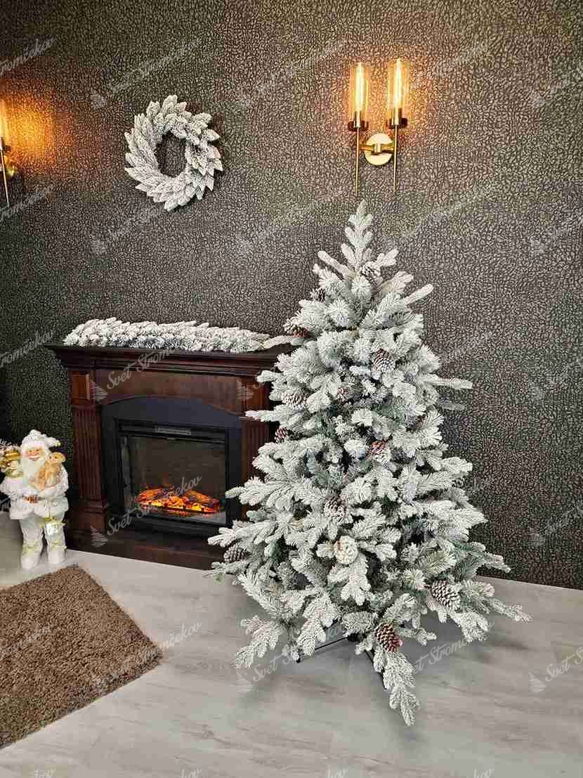 Umelý vianočný stromček 3D Smrek Polárny 150cm má husto zasnežené vetvičky ozdobené šiškami.