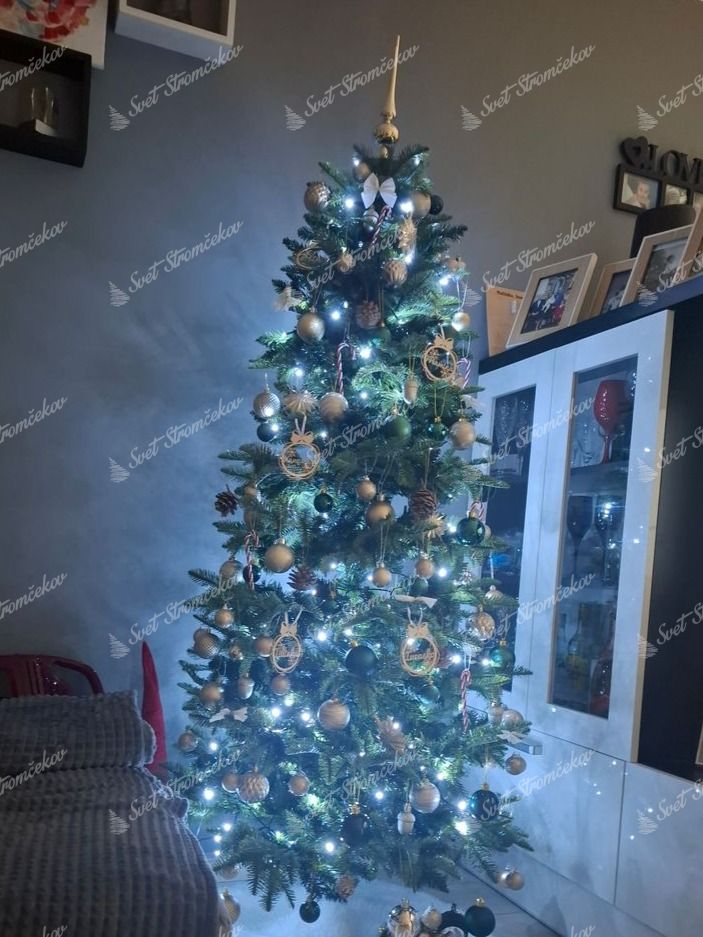 Umelý vianočný stromček 3D Jedľa Pyrenejská 180cm ozdobený čiernymi a zlatými ozdobami.