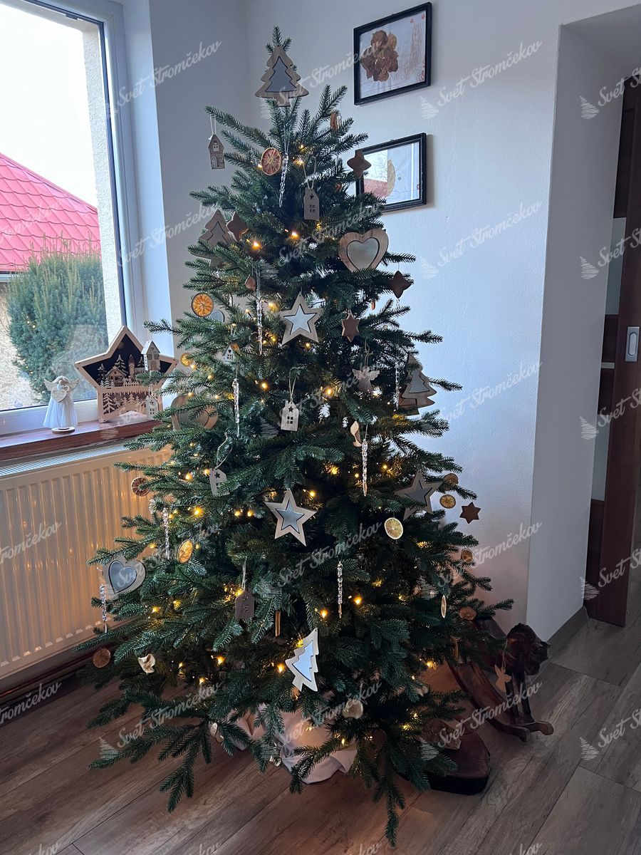 Umelý vianočný stromček 3D Smrek Horský 180cm ozdobený drevenými ozdobami a sušeným ovocím.
