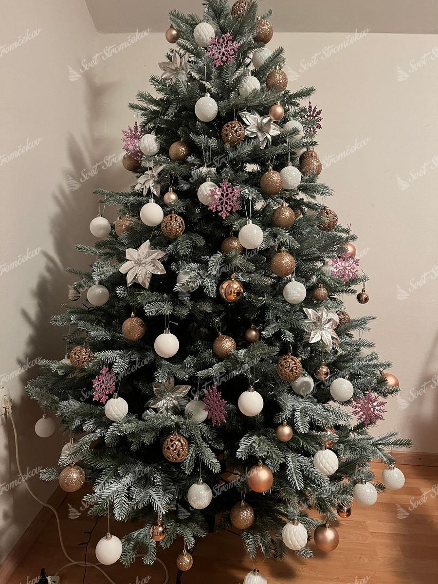 Umelý vianočný stromček 3D Smrek Strieborný 180cm, stromček je ozdobený bielymi a zlatými vianočnými guľami, ružovými vločkami a bielymi vianočnými ružami.