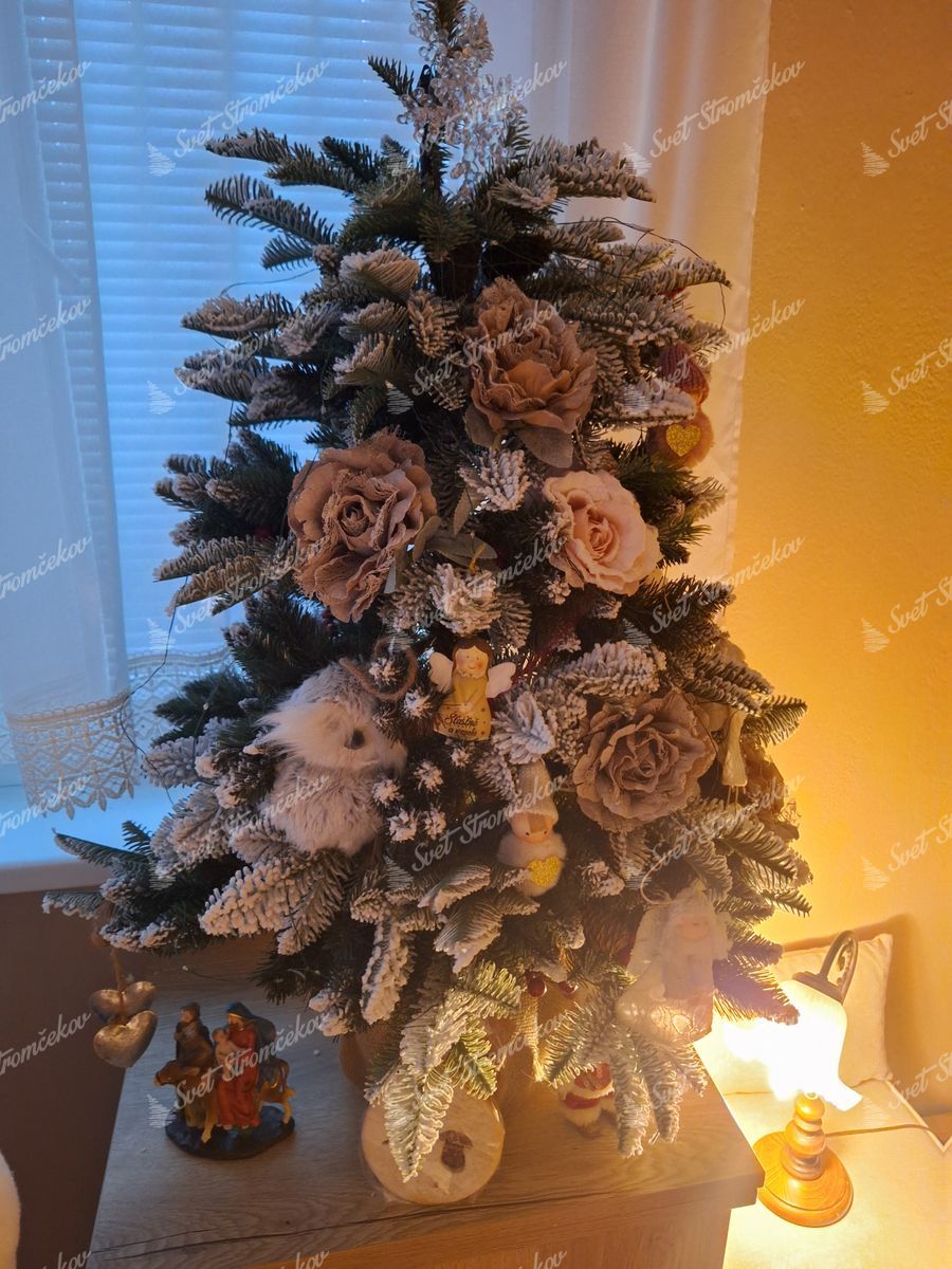 Vianočný stromček v kvetináči 3D Jedľa Zasnežená 100cm ozdobený kvetmi a figúrkami.